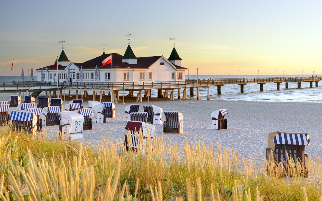Strandk&ouml;rbe reihen sich am feinen Sand von Ahlbeck, w&auml;hrend die historische Seebr&uuml;cke weit in die Ostsee ragt. Warmes Abendlicht taucht die wei&szlig;e Architektur mit gr&uuml;nen T&uuml;rmchen in goldene T&ouml;ne &ndash; ein Ort zum Durchatmen und Ankommen auf der Ostseeinsel Usedom. // &copy; Francesco Carovillano