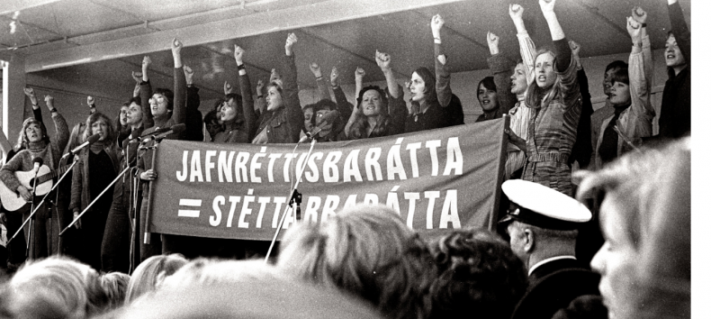 Frauen auf einer B&uuml;hne protestieren mit Banner und erhobener Faust // &copy; RiseAndShineCinema