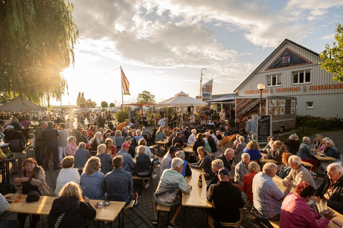 Live-muziek in de vissershaven van Ribnitz: volle bankjes, gesprekken, de geur van vis uit de rokerij &ndash; havenflair tot laat in de avond. // &copy; Ribnitzer Fischhafen/Hugo Scholz-Witzel