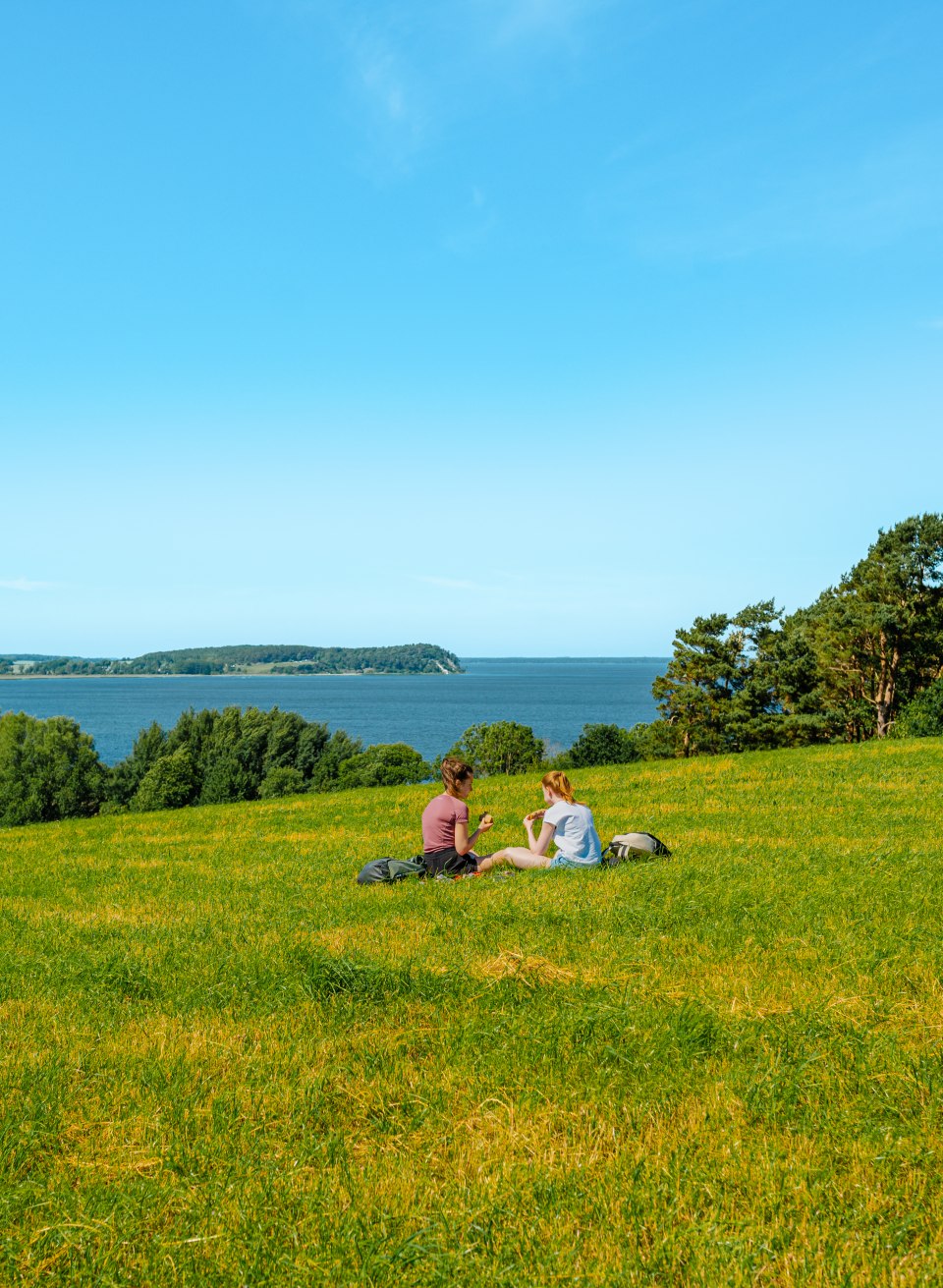 Twee vrouwen picknicken op een weiland met uitzicht op de Jasmund Bodden