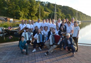 Das Jugendorchester steht im Lohme am Hafen im Hintergrund ist das Wasser zusehen. // &copy; TREMOLO nonstop