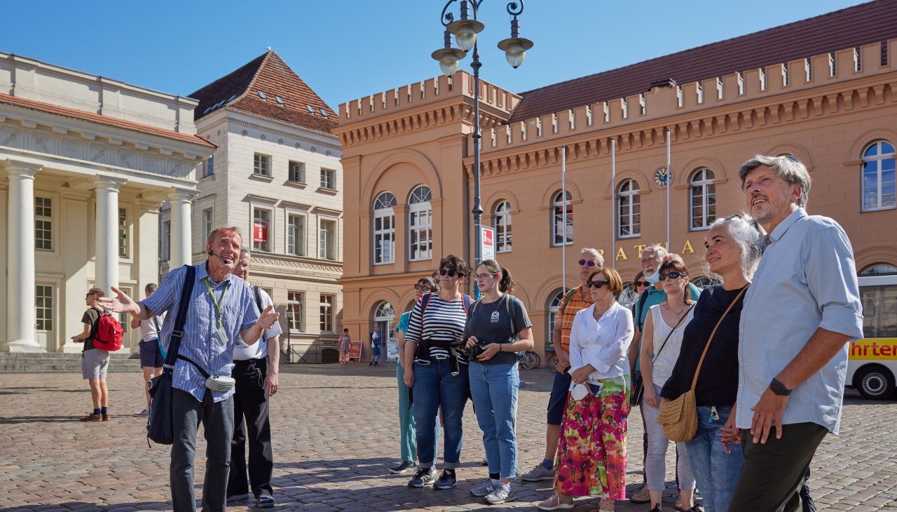 Stadtführer mit einer Gästegruppe auf dem Schweriner Markt vorm Rathaus., © Oliver Borchert Stadtführer mit einer Gästegruppe auf dem Schweriner Markt vorm Rathaus., © Oliver Borchert