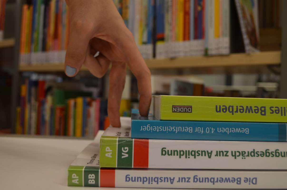Zwei Finger erklimmen symbolische eine Treppe aus B&uuml;chern, &copy; Stadtbibliothek Stralsund
