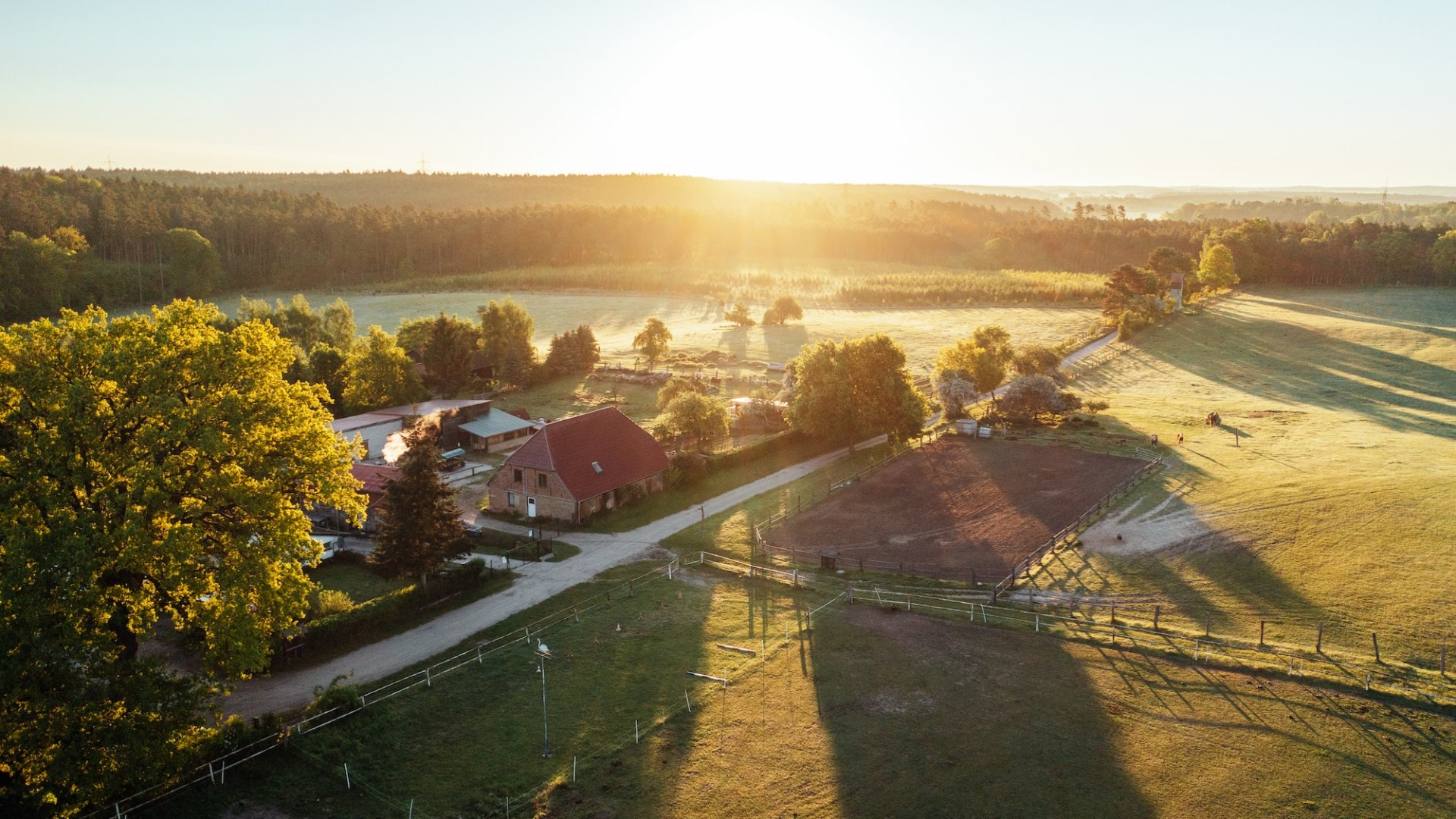 Der Waldhof Bruchmühle aus der Luft zum Sonnenuntergang. Bauernhaus mit Nebengelass und Koppel // Nichts als Natur: Der Waldhof Bruchmühle liegt zwischen Wiesen, Wäldern und Seen. // © MV-T/Gänsicke Der Waldhof Bruchmühle aus der Luft zum Sonnenuntergang. Bauernhaus mit Nebengelass und Koppel