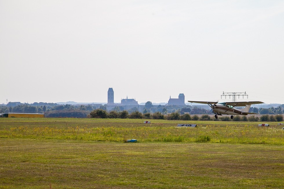 Flugzeug beim Start. Im Hintergrund die Silhouette von Wismar. // © Frank Burger Flugzeug beim Start. Im Hintergrund die Silhouette von Wismar. // © Frank Burger