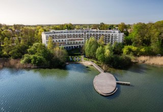 Au&szlig;enansicht Hotel mit Strand und Badeplattform // &copy; Seehotel Fleesensee