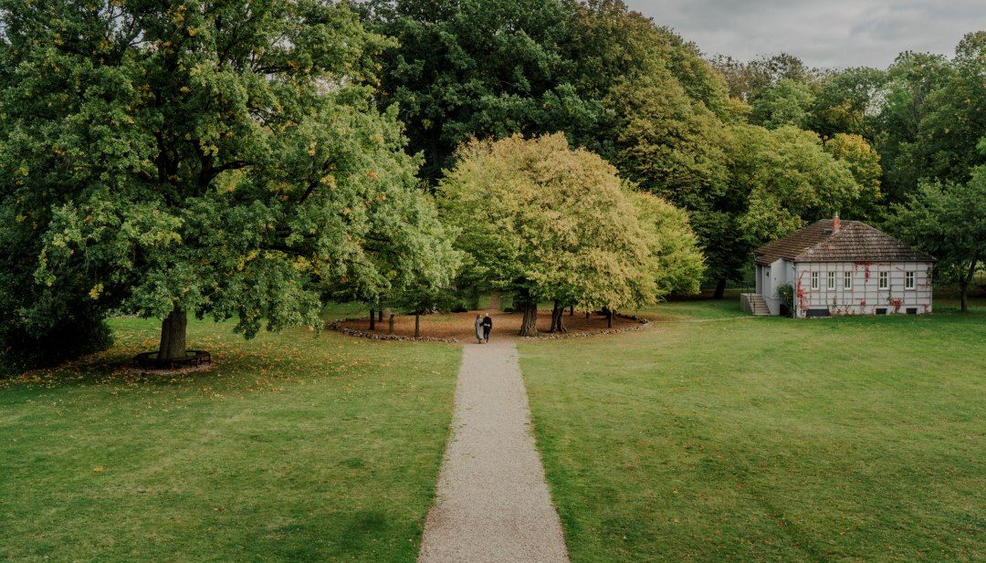 Een idyllische wandeling door het park van Romantik Hotel Gutshaus Ludorf: omringd door oude bomen en groene weiden nodigt de natuur je uit om te ontspannen en tot rust te komen.