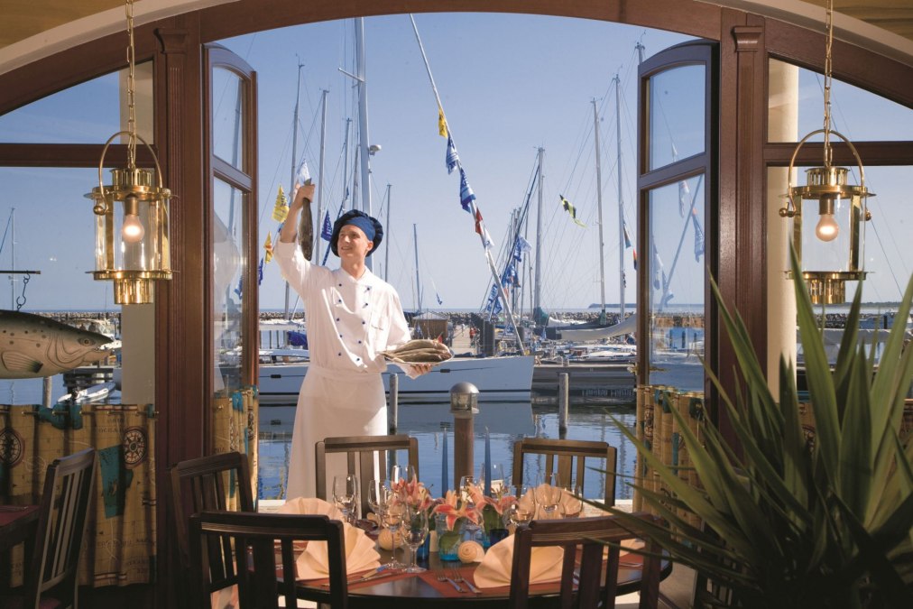 Genießen Sie Ihr Essen in stilvollem Ambiente mit Ostseeblick, es erwartet Sie u.a. italienische Pizza und frische Fischgerichte., © Yachthafenresidenz Hohe Düne, www.hohe-düne.de
