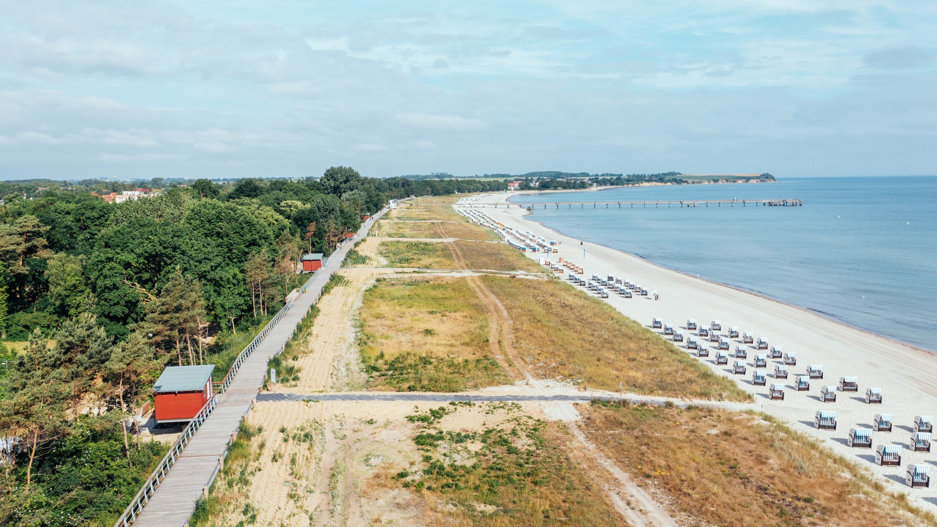 Dronenaufnahme von der Strandpromenade von Boltenhagen und dem Strand mit Seebr&uuml;cke.