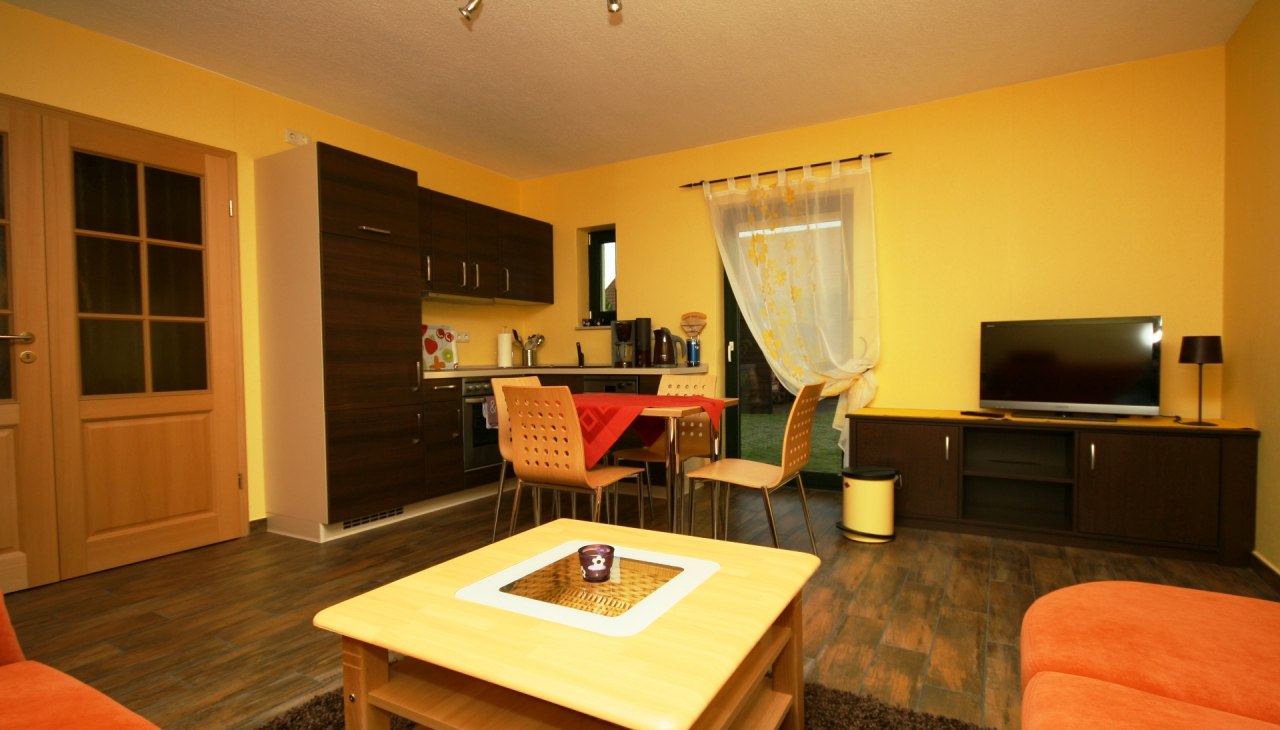 Komplett eingerichteter Essbereich mit K&uuml;hlschrank und Geschirrsp&uuml;ler sowie eingerichteter Wohnbereich mit Schlafcouch und TV., &copy; Andreas Hollstein