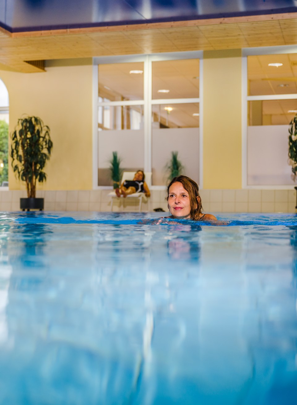 Das hauseigene Schwimmbad lädt bei jedem Wetter zum Schwimmen ein., © TMV/Tiemann Ein Frau schwimmt im hauseigenen Swimmingpool des Medical Wellness Zentrum.