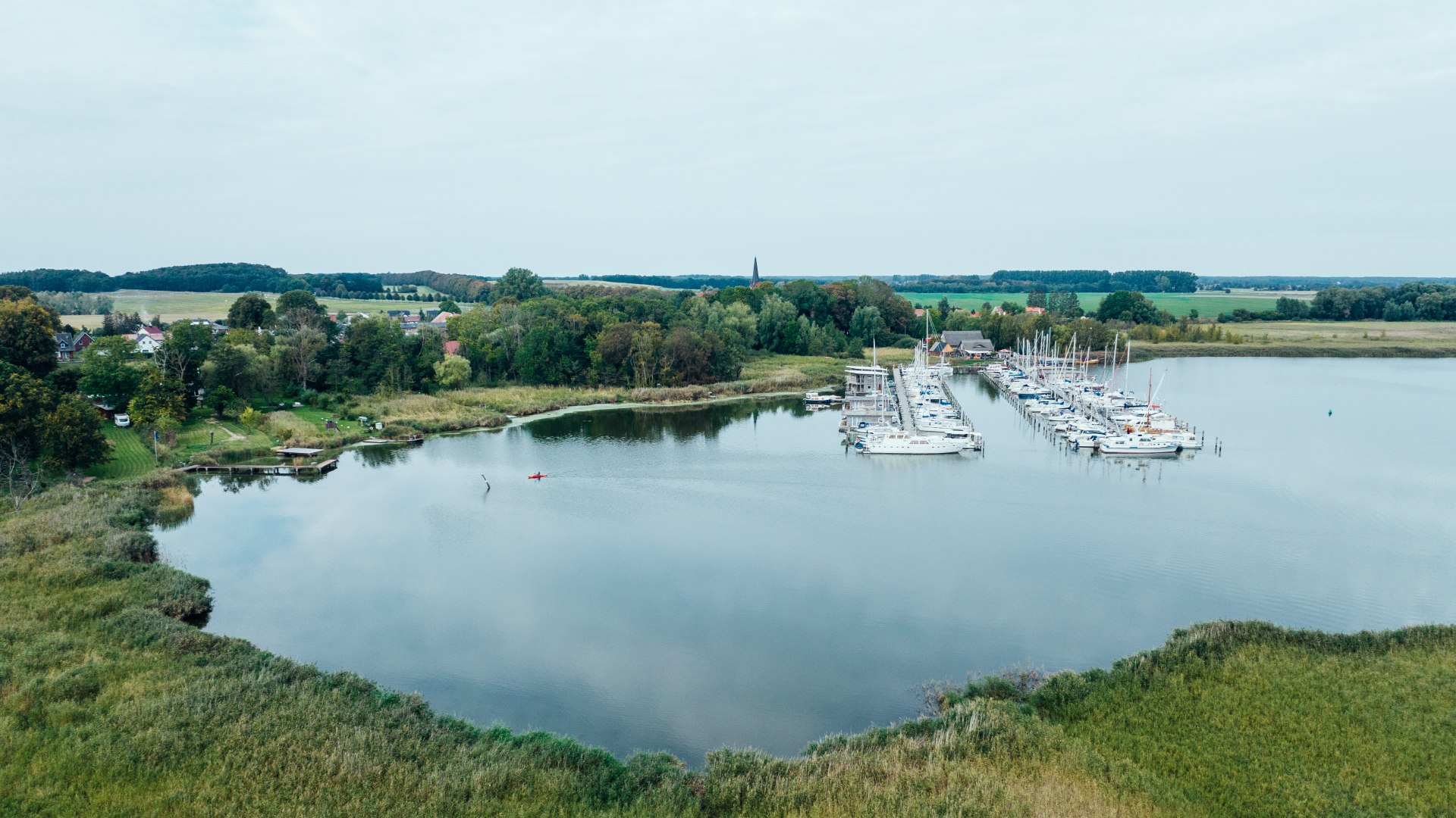 Still, grün, friedlich: Der Naturhafen Krummin auf Usedom, © TMV/Gänsicke Der Naturhafen Krummin mit Booten und Hausbooten aus der Luft.
