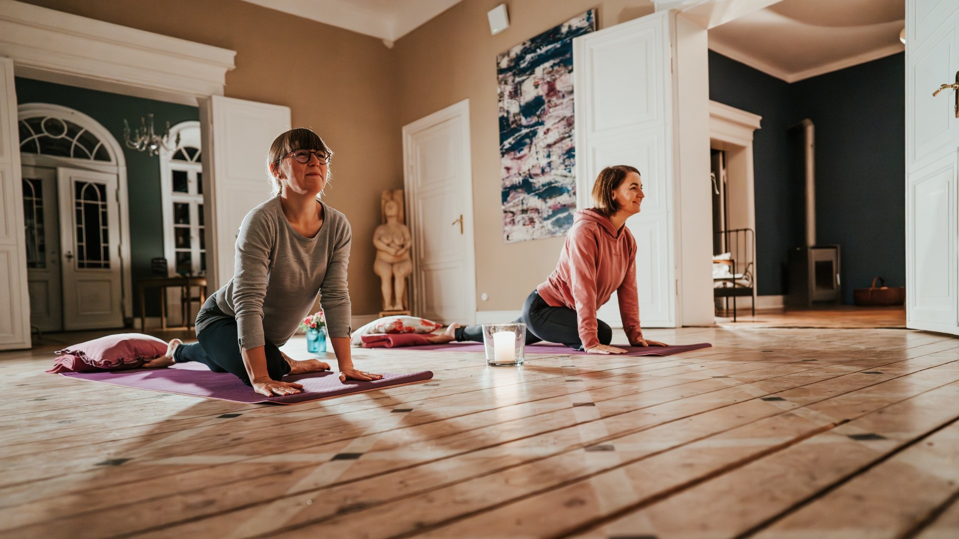 Zwei Teilnehmerinnen genießen eine Yoga-Session im Gutshaus Pohnstorf – Achtsamkeit und Bewegung in stilvoller und entspannter Umgebung. // © 1000seen.de Zwei Teilnehmerinnen genießen eine Yoga-Session im Gutshaus Pohnstorf – Achtsamkeit und Bewegung in stilvoller und entspannter Umgebung.