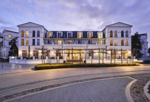Beleuchtetes Strandhotel Zingst im Stil der B&auml;derarchitektur bei D&auml;mmerung, aufgenommen von der Stra&szlig;enseite.