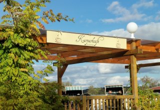 Blick von der Stra&szlig;e aus auf das Logo des Caf&eacute;s mit Strandk&ouml;rben im Hintergrund // &copy; Tortenmarie Photo