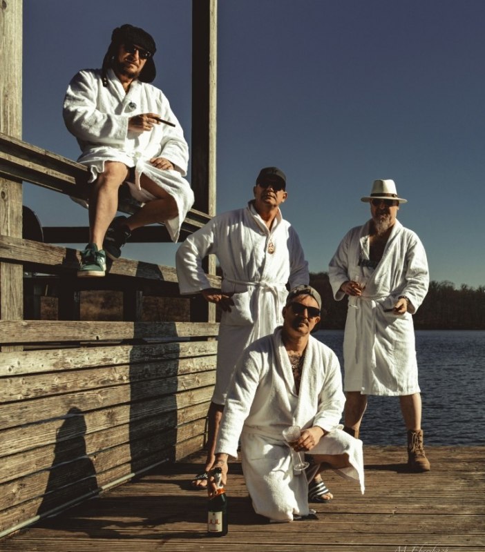 vier Musiker der Band Herb im wei&szlig;en Bademantel auf einer Badeplattform // &copy; Herb Band