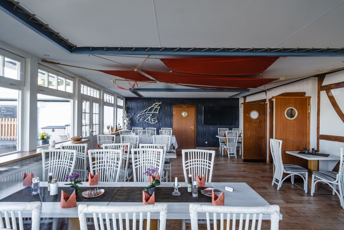Zithoek in restaurant DE ZEES in Ribnitz-Damgarten: licht, strak, maritiem &ndash; een plek bij het raam en een ruimte die rust uitstraalt. // &copy; Ribnitzer Fischhafen/Hugo Scholz-Witzel