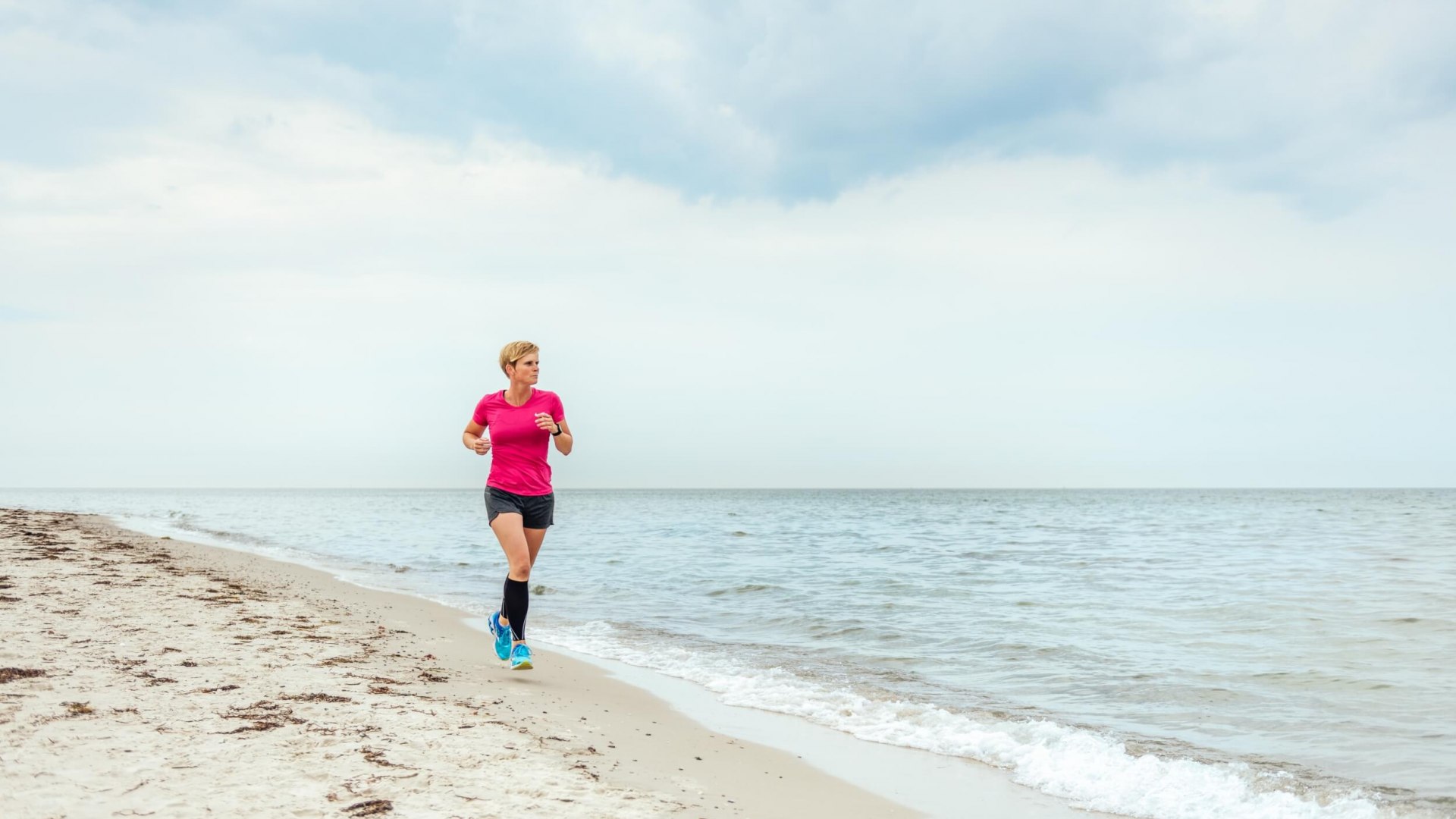Anne rent door het zand op het strand van Dierhagen