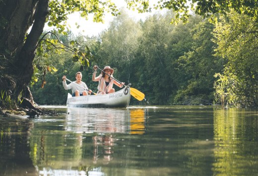 Ein Kanu paddelt am Jamelsee im Sonnenschein