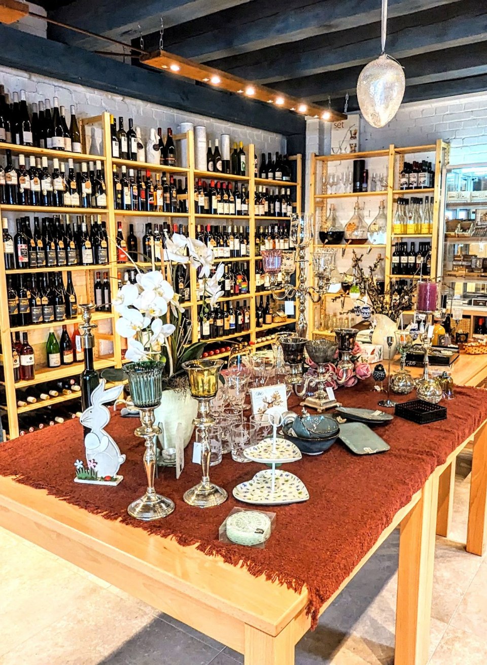 Innenraum der Weinhandlung „Weinhaus im Hof“ mit Regalen voller Weinflaschen, Feinkost und dekorativen Geschenkartikeln. // Weinerlebnis mit Charme – im „Weinhaus im Hof“ entdecken Genießer eine erlesene Auswahl regionaler und internationaler Weine sowie liebevoll präsentierte Feinkost und Geschenkideen. // © Leopold Höglinger Innenraum der Weinhandlung „Weinhaus im Hof“ mit Regalen voller Weinflaschen, Feinkost und dekorativen Geschenkartikeln.