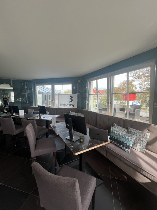 Lichte loungehoek met stijlvolle werkplekken en uitzicht op het groen., © Michelle Dynio Lichte loungehoek met stijlvolle werkplekken en uitzicht op het groen., © Michelle Dynio