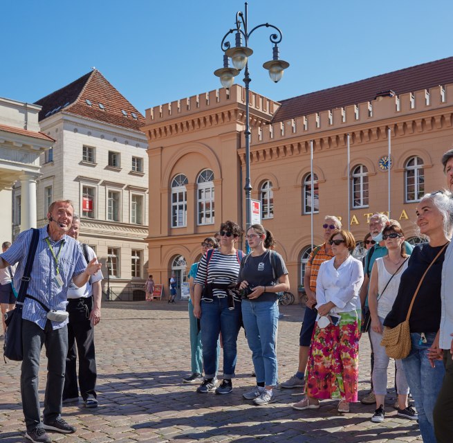 Stadtführer mit einer Gästegruppe auf dem Schweriner Markt vorm Rathaus. // © Oliver Borchert Stadtführer mit einer Gästegruppe auf dem Schweriner Markt vorm Rathaus. // © Oliver Borchert