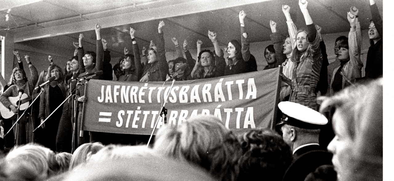 Frauen auf einer B&uuml;hne protestieren mit Banner und erhobener Faust // &copy; RiseAndShineCinema
