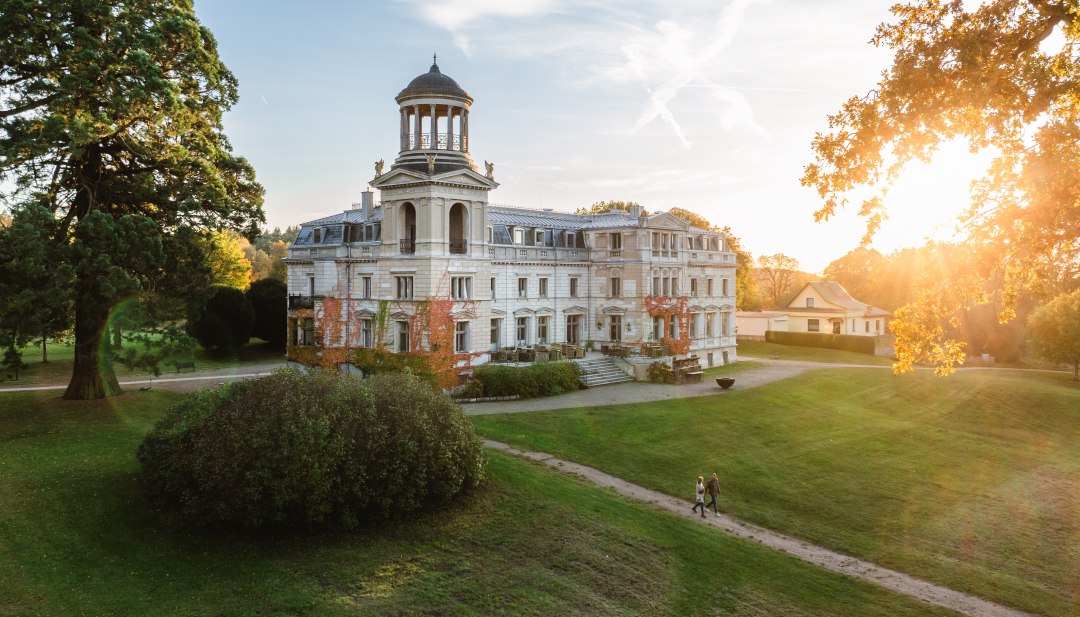 Schloss Kaarz in Mecklenburg im Abendlicht, umgeben von Parkanlagen und Besuchern zur MittsommerRemise.