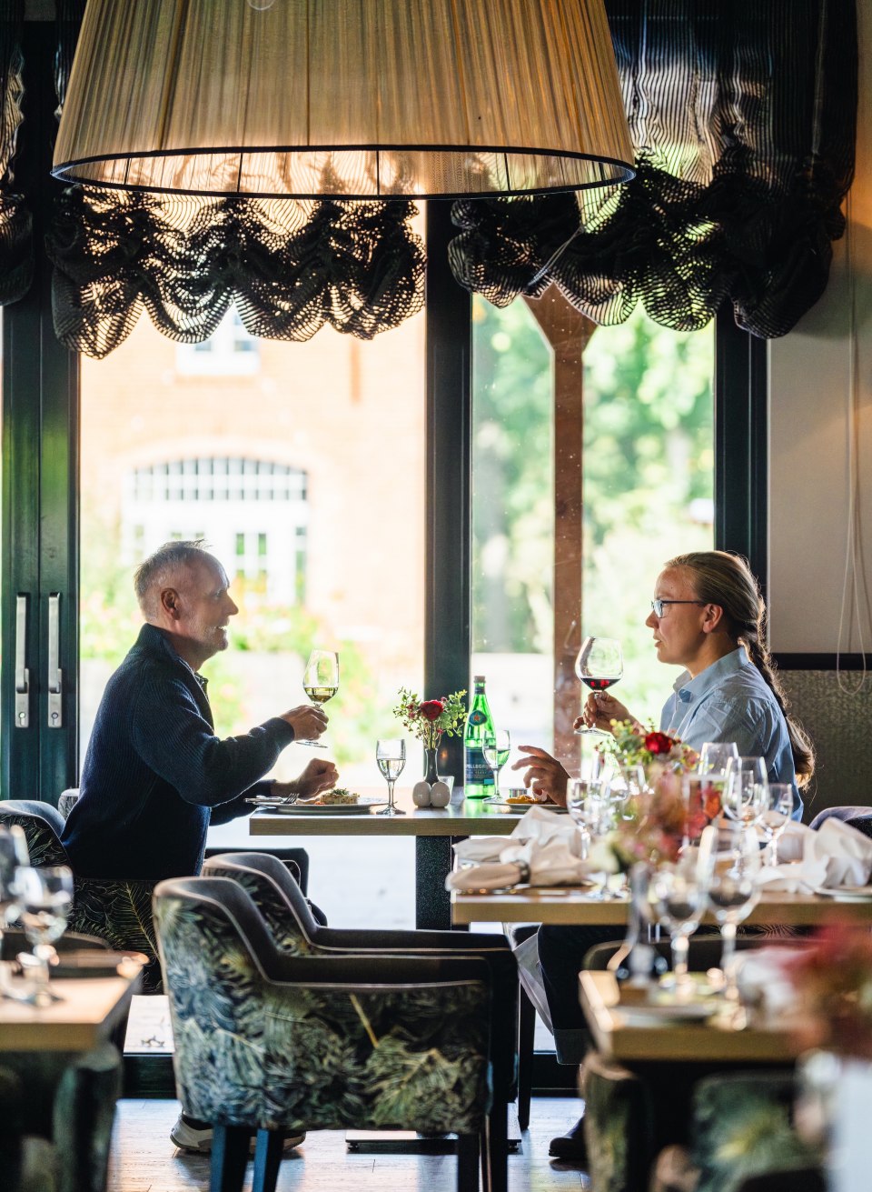 Zwei Personen stoßen mit einem Glas Wein an, während sie ein elegantes Mittagessen im Restaurant vom Schloss Basthorst genießen. // Kulinarische Highlights genießen – Mittagessen im stilvollen Ambiente des Schloss Basthorst. // © MV-T/Gross Zwei Personen stoßen mit einem Glas Wein an, während sie ein elegantes Mittagessen im Restaurant vom Schloss Basthorst genießen.