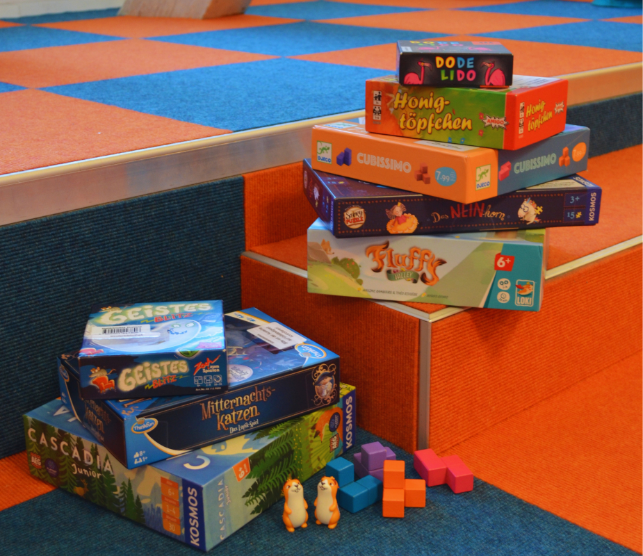 Viele verschiedene Gesellschaftsspiele wurden übereinandersgestapelt und Spielfiguren präsentiert. // © Stadtbibliothek Stralsund Viele verschiedene Gesellschaftsspiele wurden übereinandersgestapelt und Spielfiguren präsentiert. // © Stadtbibliothek Stralsund