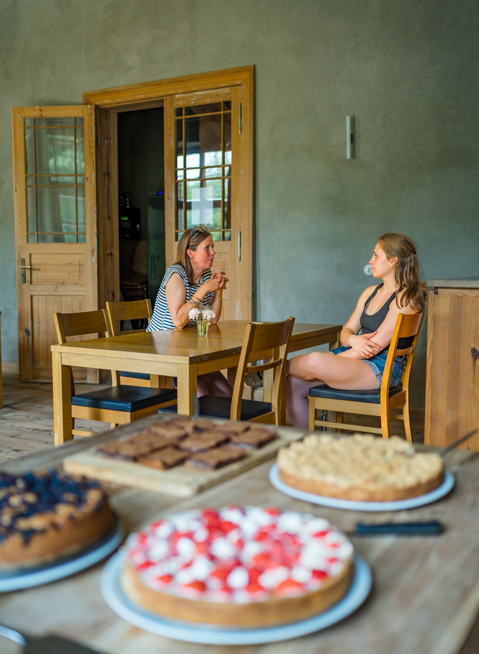 Pauze in het landhuis: de taarten van Franziska Hesse in het landhuis Linstow zijn moeilijk te weerstaan - moeder en dochter zitten aan tafel met de selectie taarten op de voorgrond