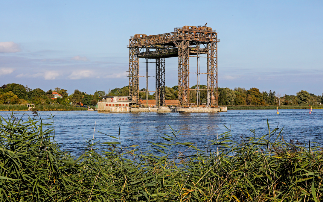 Die historische Hubbrücke Karnin über dem Wasser öffnet den Weg für Schiffe. Zwischen Schilf und ruhigem Ufer spürbar: Mecklenburgische Geschichte, die den Fluss lebendig hält. // © MV-T/Gohlke Die historische Hubbrücke Karnin über dem Wasser öffnet den Weg für Schiffe. Zwischen Schilf und ruhigem Ufer spürbar: Mecklenburgische Geschichte, die den Fluss lebendig hält. // © MV-T/Gohlke