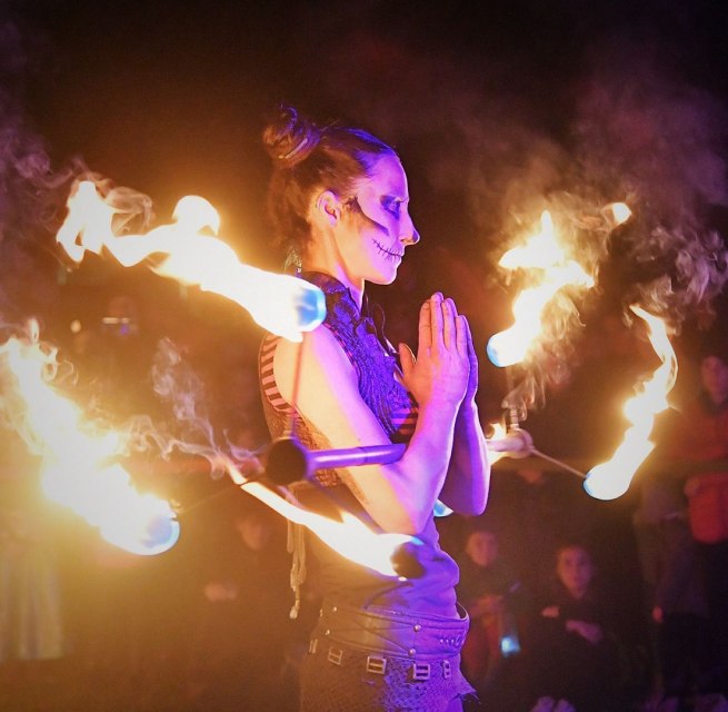 Beim Lampionfest im Zoo Rostock führt eine Frau mit Gesichtsschminke eine Feuershow vor und hält einen brennenden Stab in der Hand. // © Zoo Rostock/ Kloock Beim Lampionfest im Zoo Rostock führt eine Frau mit Gesichtsschminke eine Feuershow vor und hält einen brennenden Stab in der Hand. // © Zoo Rostock/ Kloock