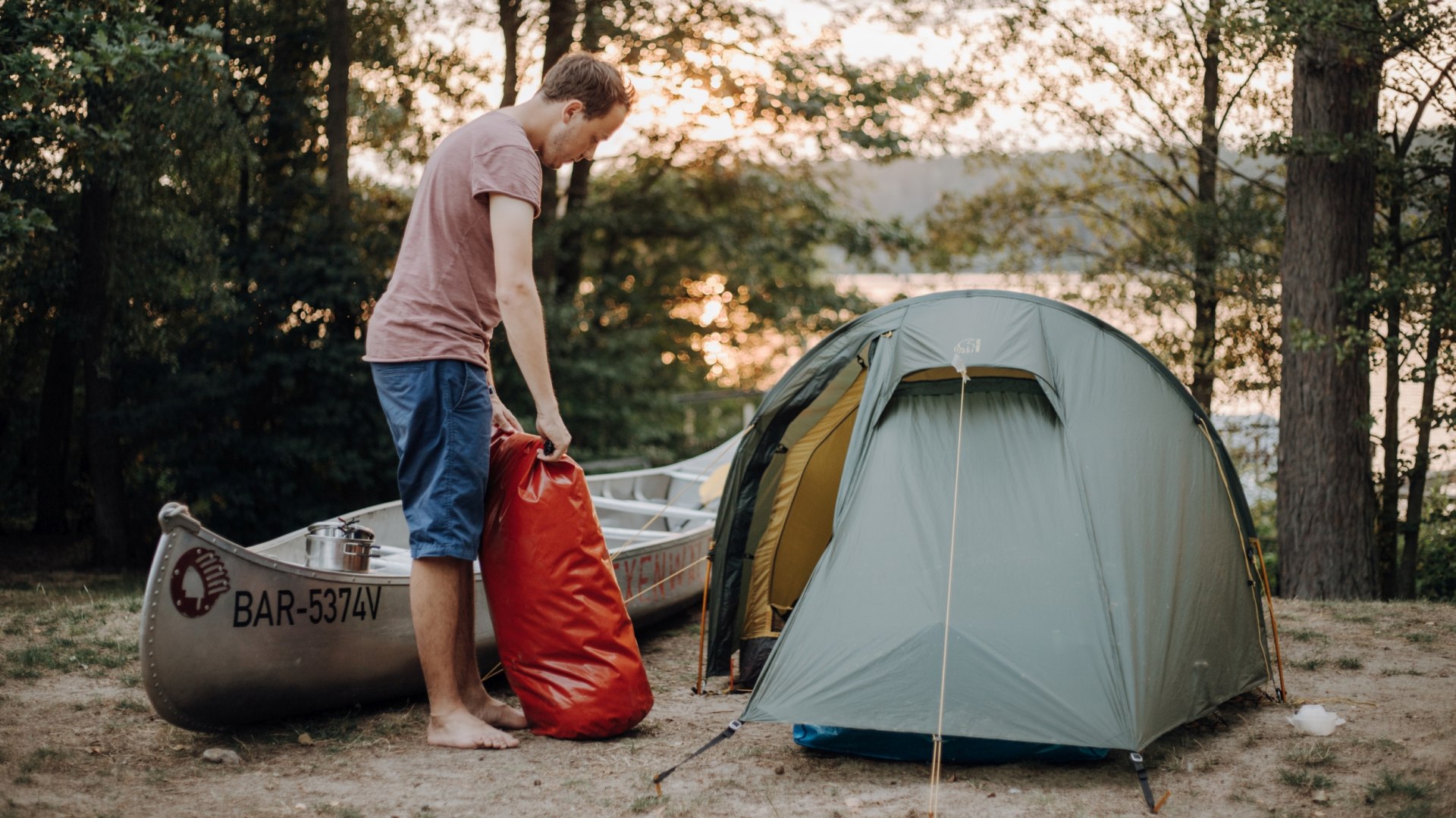 Camping ved Labussee &ndash; En person sl&aring;r et telt op i solnedgangen