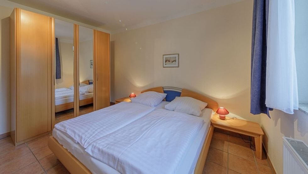 Slaapkamer met groot tweepersoonsbed en kledingkast // &copy; Andre Pretzel