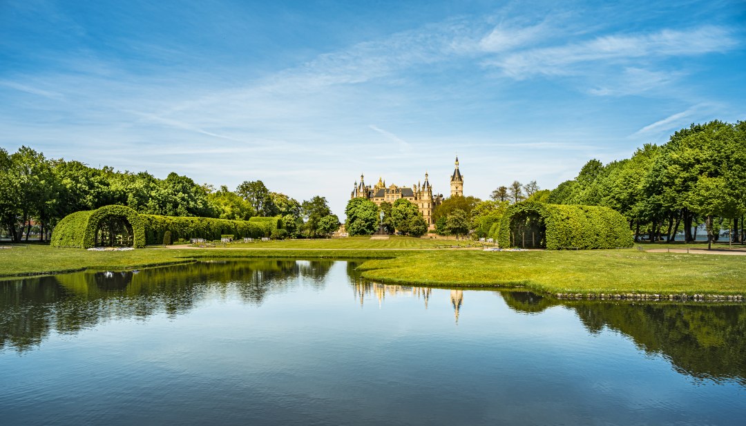 Der Schlossgarten und Schlosspark in Schwerin &uuml;ber die Gartenkan&auml;le und Blick auf das Schloss.