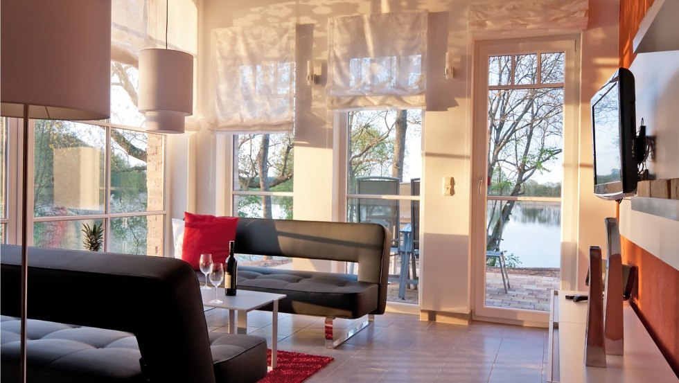 Wohnbereich der Ferienwohnung Fischadler mit großen Scheunenfenstern // © Andre Pretzel Wohnbereich der Ferienwohnung Fischadler mit großen Scheunenfenstern // © Andre Pretzel