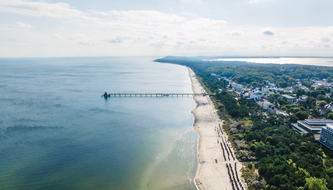 Luftaufnahme vom Strand und der Seebr&uuml;cke in Zinnowitz auf Usedom mit Blick &uuml;ber die Ostsee und den K&uuml;stenwald.