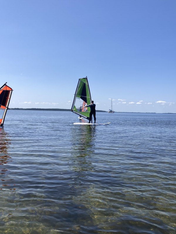 Windsurfkurs für Anfänger am Salzhaff in Rerik: Teilnehmer lernen die Grundlagen im flachen Wasser unter Anleitung der Surfschule Rerik. Das Stehrevier bietet ideale Bedingungen für einen sicheren und schnellen Einstieg ins Windsurfen an der Ostsee. // © Henning Schult Windsurfkurs für Anfänger am Salzhaff in Rerik: Teilnehmer lernen die Grundlagen im flachen Wasser unter Anleitung der Surfschule Rerik. Das Stehrevier bietet ideale Bedingungen für einen sicheren und schnellen Einstieg ins Windsurfen an der Ostsee. // © Henning Schult