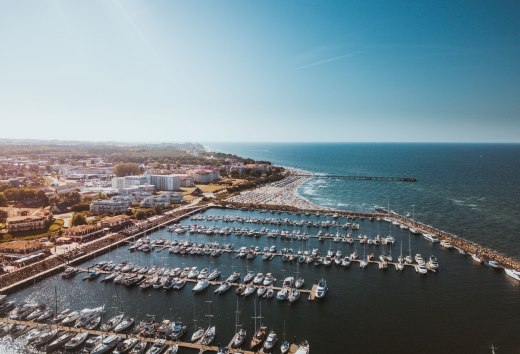 Luftaufnahme vom Yachthafen K&uuml;hlungsborn mit Booten, Strand und Ostsee bei Sonnenschein.