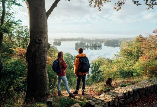 Ein Pärchen schaut vom Reiherberg in Feldberg von oben auf den Feldberger Haussee // Wandern auf dem Naturparkweg am Aussichtspunkt Reiherberg in Feldberg // © MV-T/Gänsicke Ein Pärchen schaut vom Reiherberg in Feldberg von oben auf den Feldberger Haussee