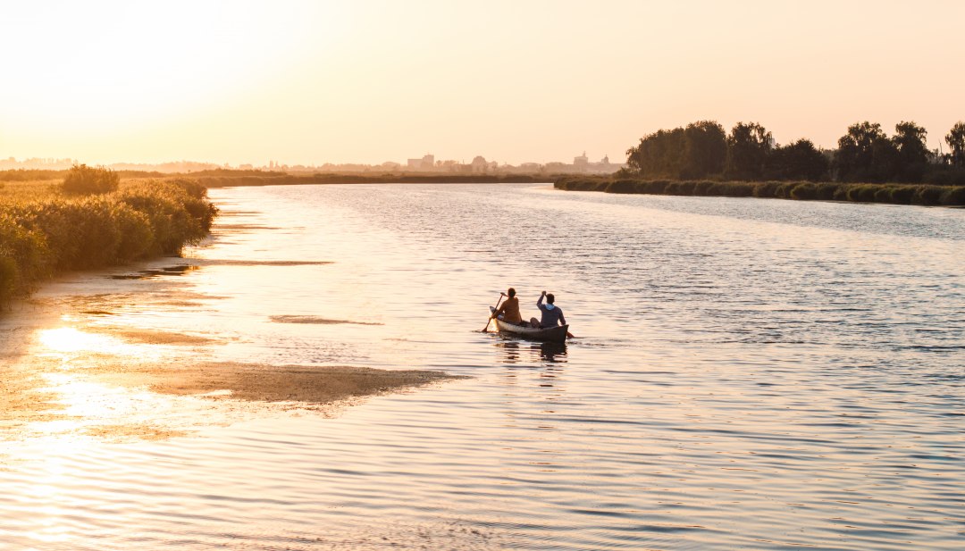 Ein ruhiger Abend auf dem Wasser: Zwei Personen paddeln bei Sonnenuntergang durch die weiten Gewässer Vorpommerns, umgeben von Natur und Stille. // © MV-T/Gross Ein ruhiger Abend auf dem Wasser: Zwei Personen paddeln bei Sonnenuntergang durch die weiten Gewässer Vorpommerns, umgeben von Natur und Stille.