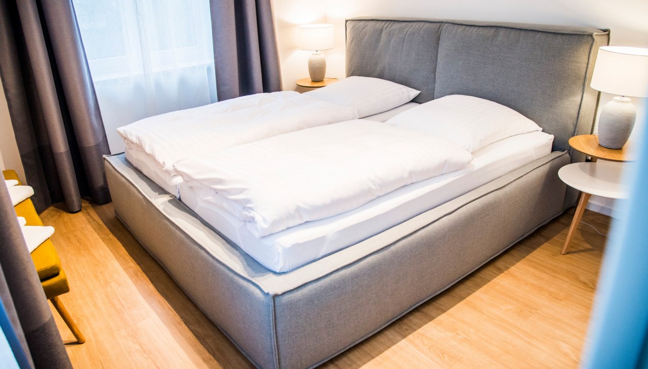 Ein Schlafzimmer ist mit Doppelbett, das zweite jeweils mit zwei Einzelbetten ausgestattet, &copy; Lichthof Neubrandenburg