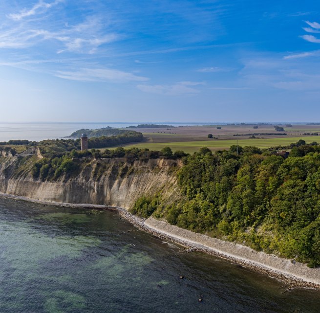 Luftaufnahme des Kap Arkona auf Rügen, mit seinen zwei Leuchttürmen und der steilen Kreideküste, umgeben von Feldern und der Ostsee unter klarem Himmel.