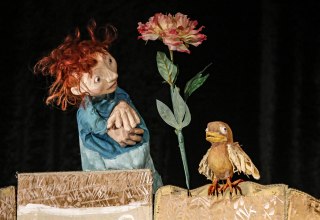Afbeelding van een sc&egrave;ne uit het toneelstuk met het kleine vrouwtje, een bloem en een vogel // &copy; Klaus Schiebold