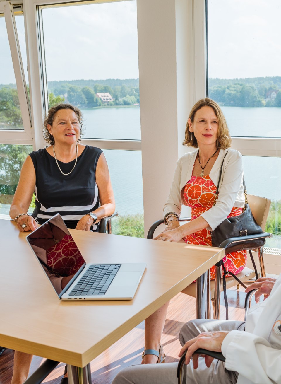 Bei jedem Medical Wellness-Aufenthalt findet zunächst ein Arztgespräch statt., © TMV/Tiemann Zwei Frauen sitzen an einem Tisch in einem Raum und führen ein Gespräch mit einem Arzt.