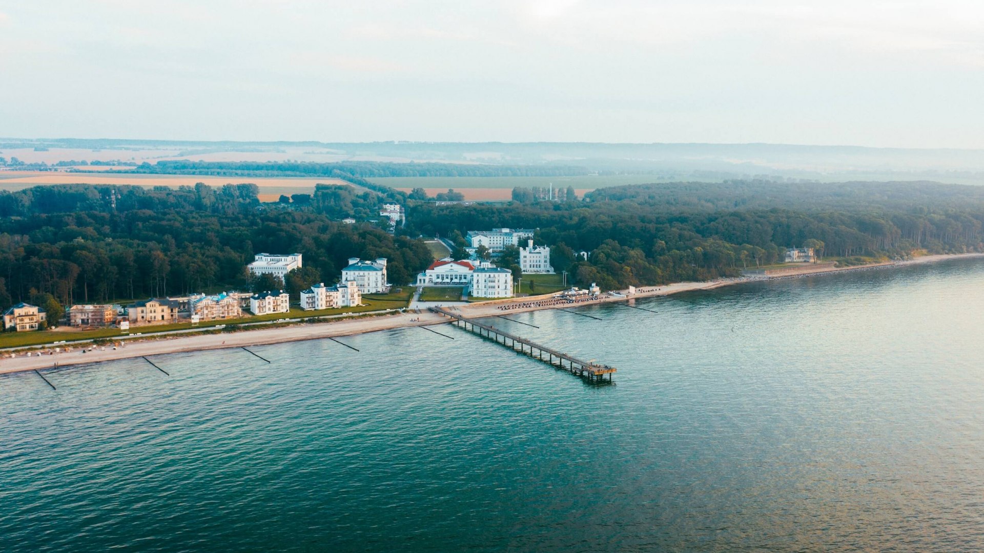 Heiligendamm – das älteste Seebad Deutschlands mit seiner beeindruckenden Architektur und der Seebrücke, eingebettet in die Natur der Ostseeküste., © TMV/Friedrich Luftaufnahme des Seebads Heiligendamm an der Ostseeküste mit klassizistischer Bäderarchitektur, dem Grand Hotel Heiligendamm und der Seebrücke.