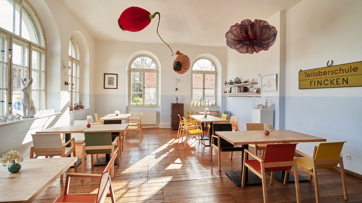 Das Restaurant "Klassenzimmer" befindet sich in einem der ehemaligen Unterrichtsr&auml;umen der Teiloberschule Fincken, die &uuml;ber 60 Jahre lang das Kavaliershaus des Schlo&szlig; Bl&uuml;cher mit Leben f&uuml;llte. Teil der ablesbaren (Ge)schichte des Geb&auml;udes sind nun Kunstwerke zweier &ouml;sterreichischer K&uuml;nstlerinnen: Die kinetische Skulptur von Theres Cassini (Verbotene Fr&uuml;chte) f&uuml;llt den Raum mit leisen, st&auml;ndigen Bewegungen und das Werk von Deborah Sengl (a.d. Serie Karl Kraus: Die letzten Tage der Menschheit) verbindet die letzte mit der neuen Nutzung: eine taxidermische Klasse lernt den Satz in S&uuml;tterlin-Schrift an der Tafel: Pfleget den Fremdenverkehr - unsere Aufgabe an diesem Ort mit einer aussergew&ouml;hnlichen, regionalen, frischen K&uuml;che eines weiteren K&uuml;nstlers, den Mecklenburger Gunnar M&uuml;ller, der jedes Jahr Neues schafft, und so den 2. ehemaligen Klassenzimmer weiterhin als Ort zum Lernen nutzt und dies liebevoll in jedem Detail, in jeder Zutat seiner Speisen zu kommunizieren wei&szlig;! // &copy; Henryk Weiffenbach / Kavaliershaus