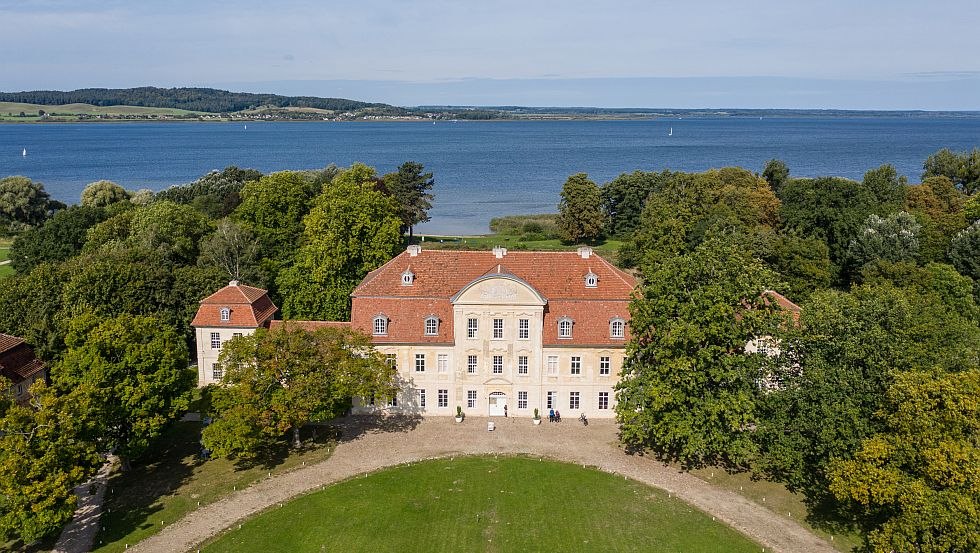 Luftaufnahmen von Schloss Kumerow, im Hintergrund glitzert der blaue See // &copy; Tourismusverband Mecklenburgische Seenplatte/Tobias Kramer