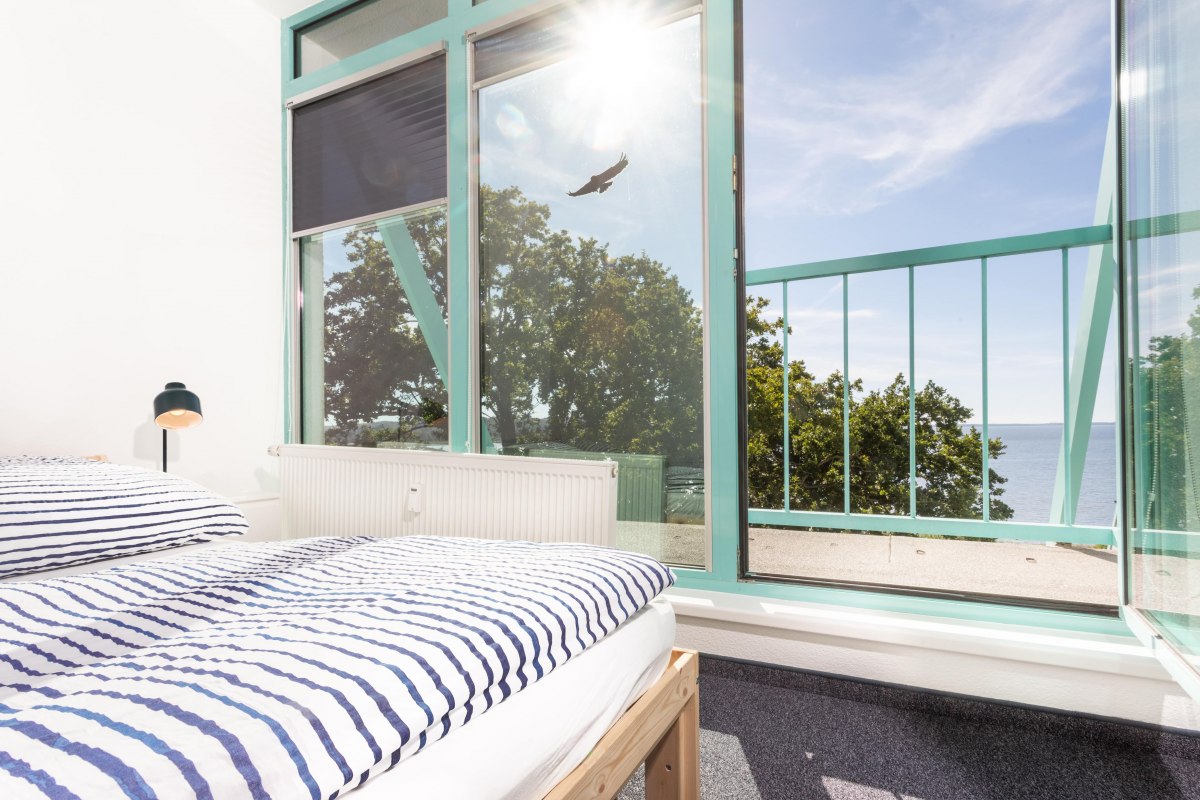 Helles Schlafzimmer mit Blick auf den Bodden, perfekt f&uuml;r Erholung nach einem produktiven Arbeitstag. // &copy; Project Bay